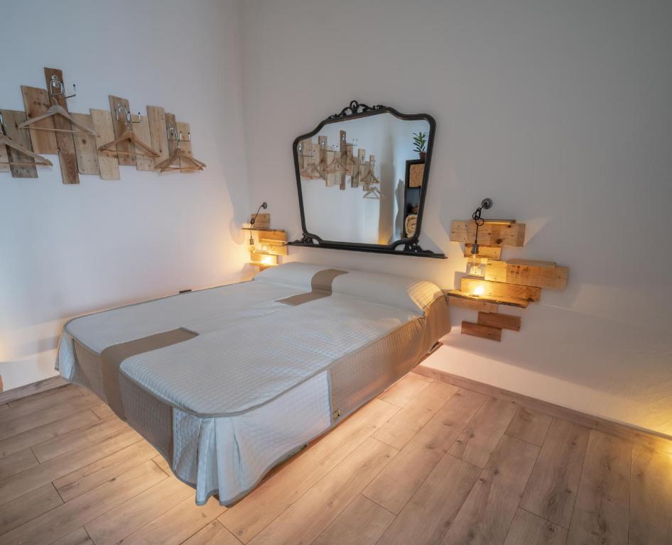 een slaapkamer met een bed met een spiegel aan de muur bij La casa della moda in Montescaglioso