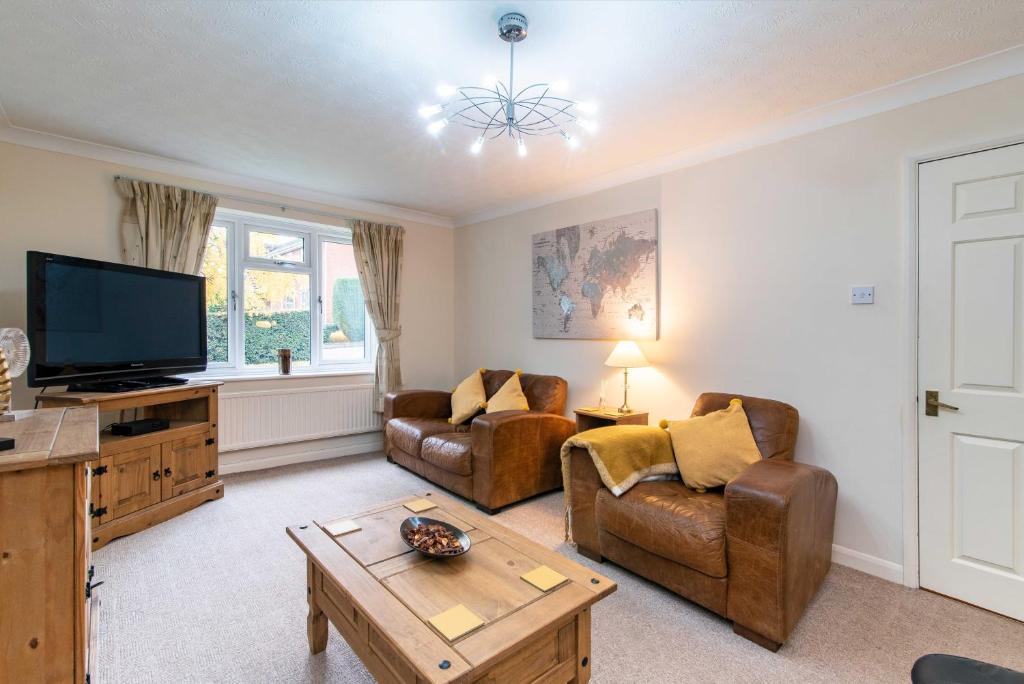 a living room with couches and a tv and a table at 4 Bed House in Castle Donington (EMA) with parking in Castle Donington