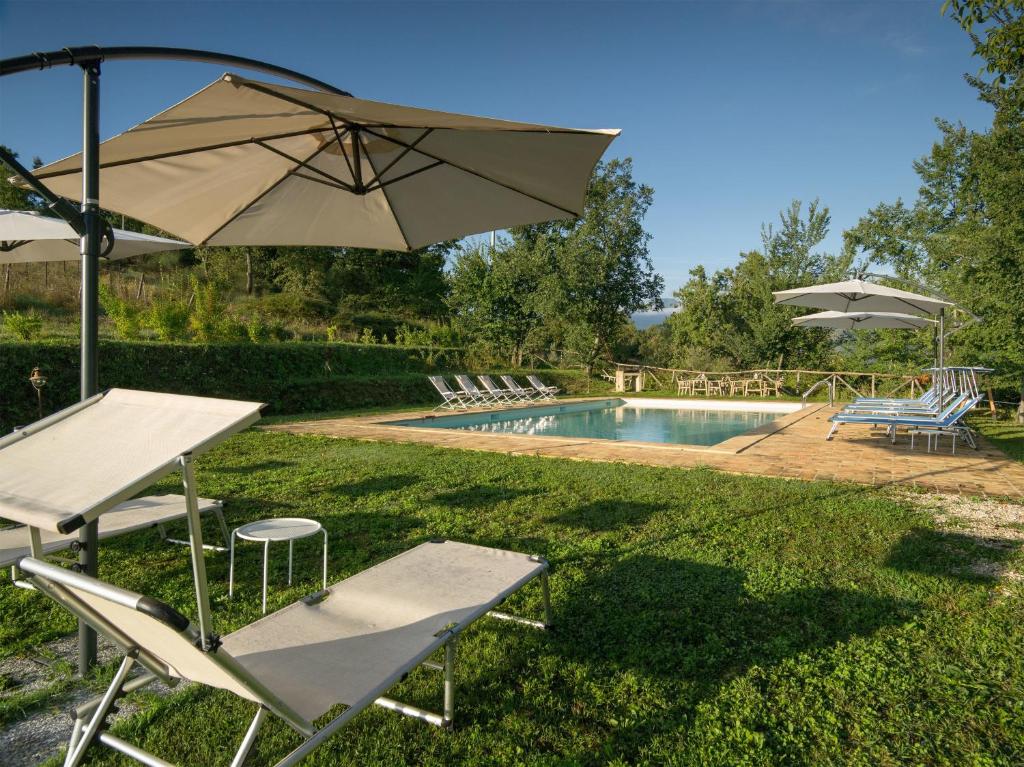 薩爾納諾的住宿－Agriturismo Serpanera，一个带桌子、遮阳伞和椅子的游泳池