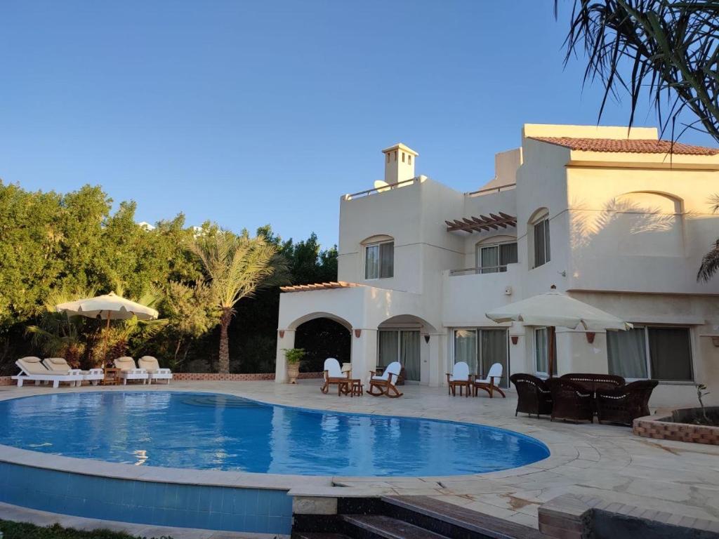 a villa with a swimming pool in front of a house at GS 18 Villa in Hurghada