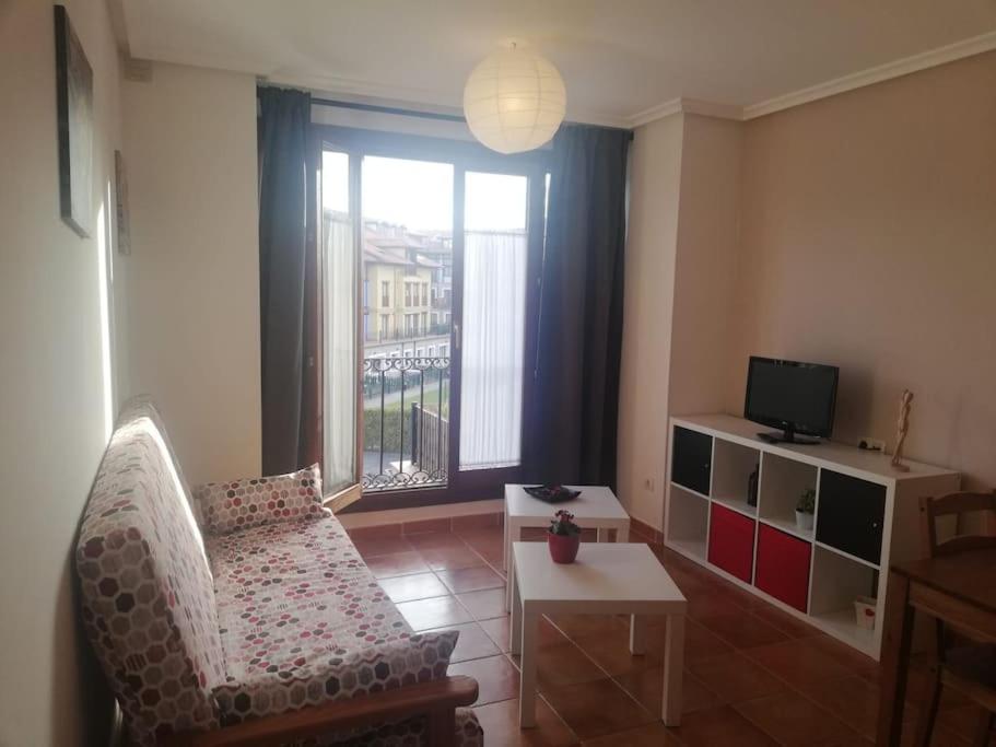 a living room with a chair and a large window at Apartamento Colombres in Colombres