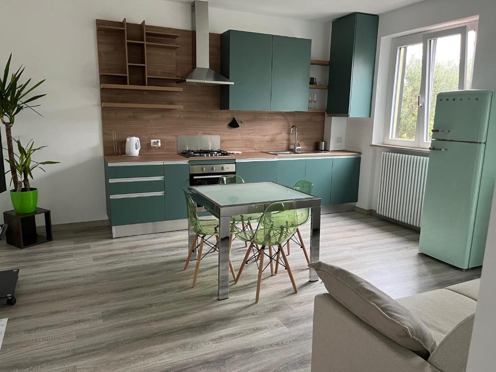 Una cocina con gabinetes verdes y una mesa y sillas. en Business Loft, en Civitanova Marche