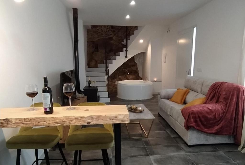 sala de estar con sofá y mesa con copas de vino en Loft Casa del Agua Ubrique, en Ubrique