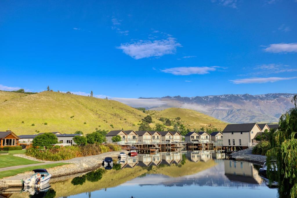 uma vista para um rio com casas e uma montanha em Marsden Lake Resort Central Otago em Cromwell