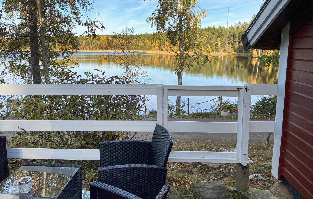 - une terrasse couverte avec 2 chaises et une vue sur le lac dans l'établissement Awesome Home In Kolmrden With House Sea View, à Kolmården