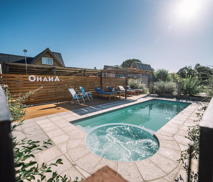 a swimming pool in a backyard with a wooden fence at OHANA in Sierra de la Ventana