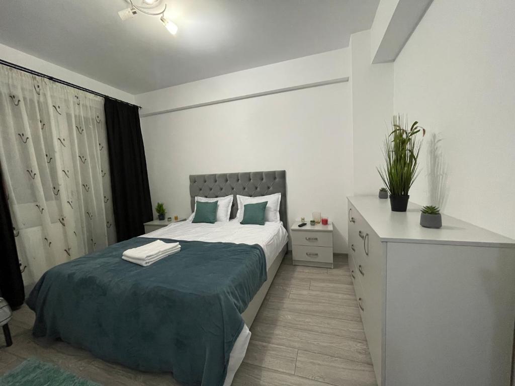 Cette chambre comprend un grand lit avec des draps verts et une commode. dans l'établissement Luxury Charming Apartments, à Iaşi