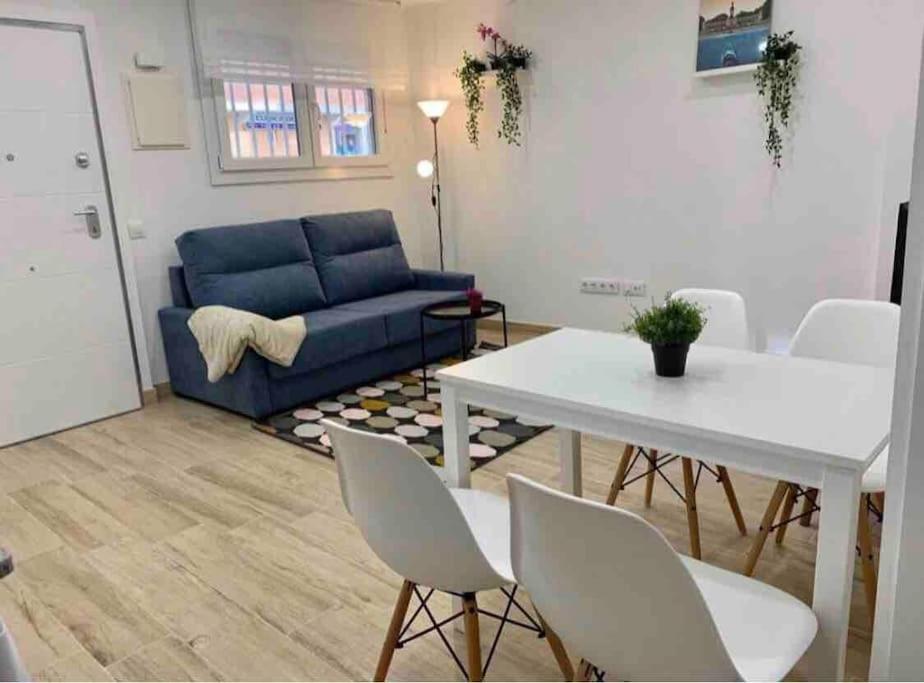 - un salon avec un canapé bleu et une table dans l'établissement Apartamento 4 personas, à Madrid