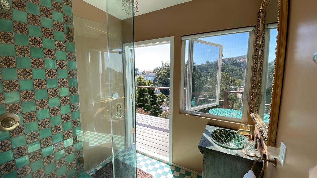Glamping Hollywood Hills - Luxury Tiny House في لوس أنجلوس: حمام مع دش مع نافذة ومغسلة
