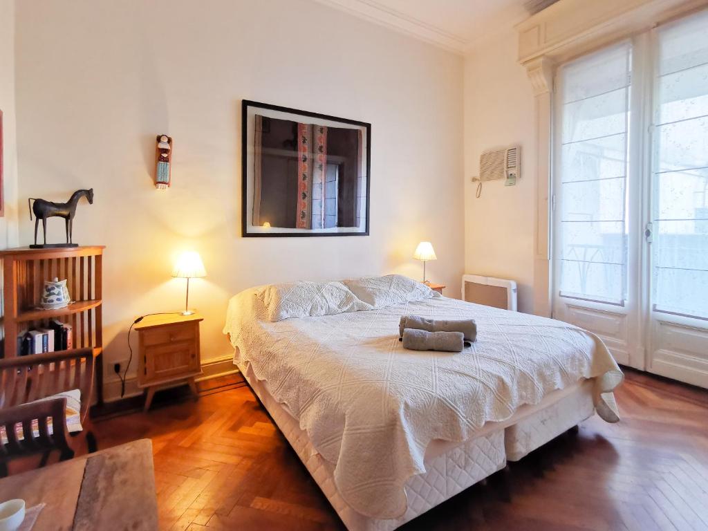 a bedroom with a bed and a table and two lamps at Via Arriba B&B in Buenos Aires