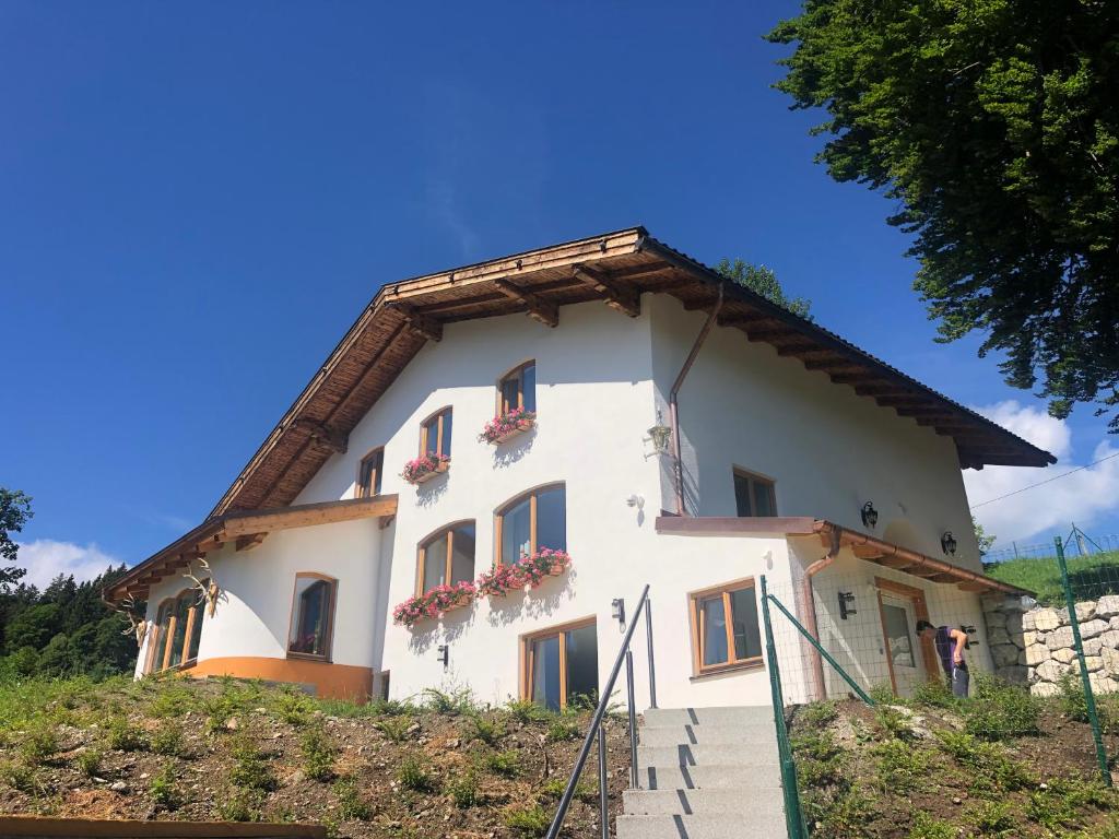 a white building with flower boxes on it at Red Deer Resort in Bad Wiessee