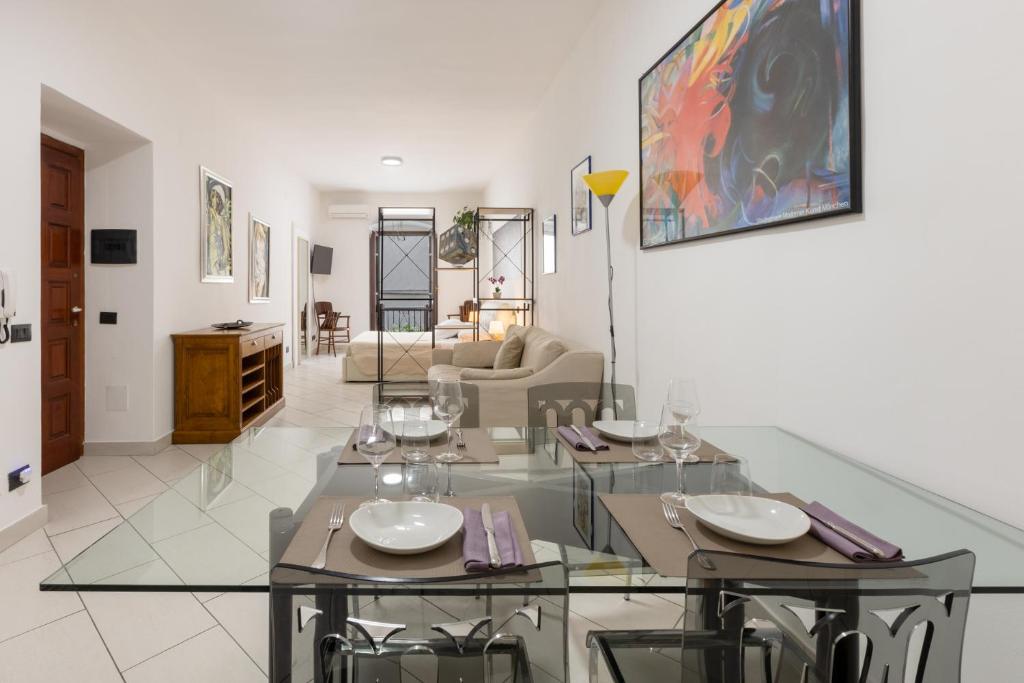 Locanda del buongustaio في كالياري: غرفة طعام مع طاولتين وغرفة معيشة