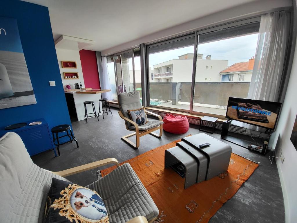 a living room with a couch and a large window at loft avec parking et terrasse in Chamalières