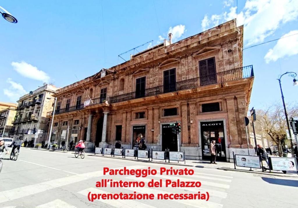 un antiguo edificio en una calle de la ciudad con gente delante en Palazzo Galati Palermo, en Palermo