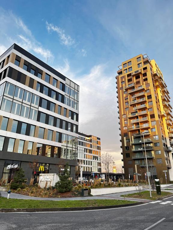 two tall buildings in a city with a street at Ein Park Apartment with free parking in Bratislava