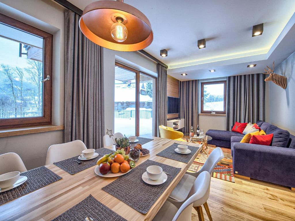 una sala de estar con una mesa de comedor con fruta. en VisitZakopane - My Deer Apartment en Zakopane