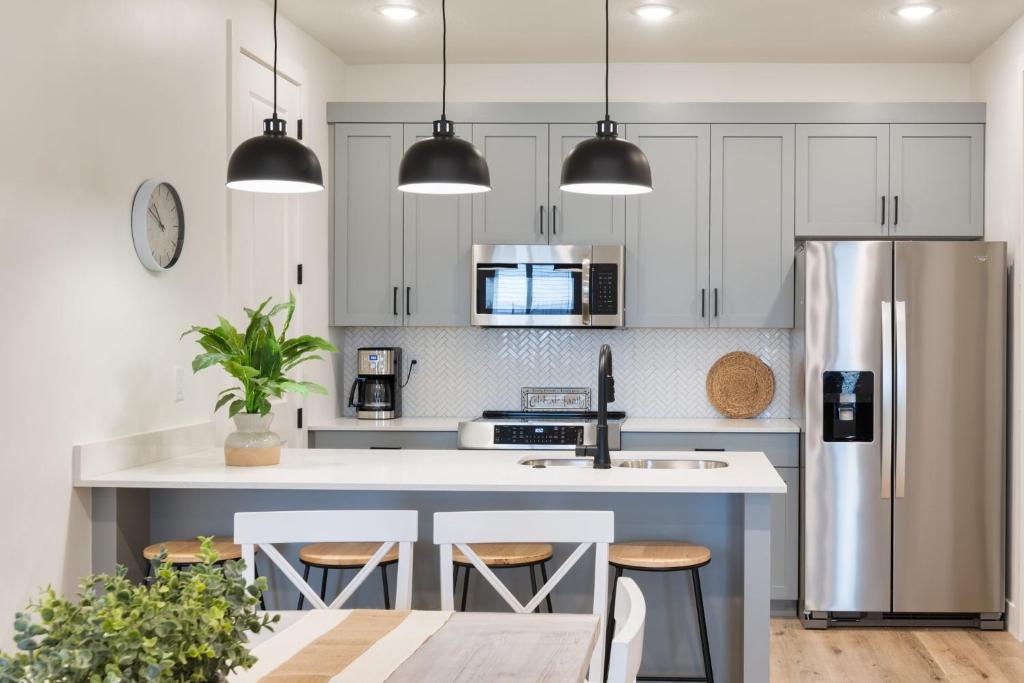 a kitchen with white cabinets and stainless steel appliances at Sun, Sand, and Smiles #100 condo in St. George