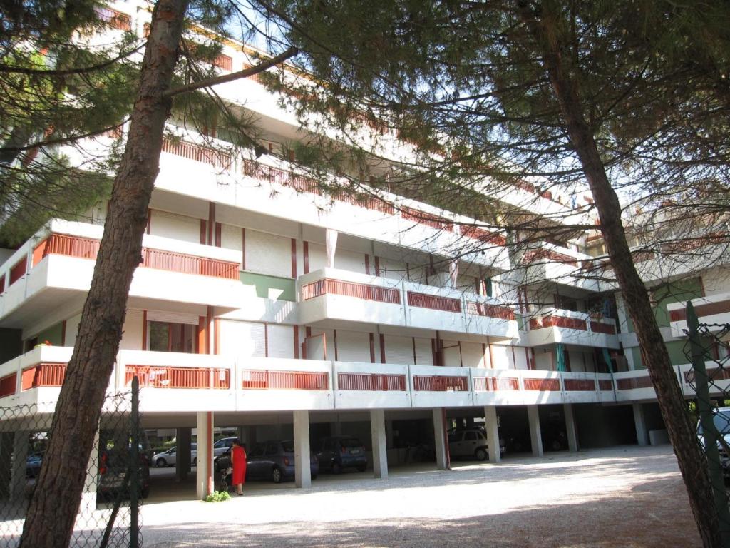 a building with trees in front of it at Appartamento Pineta Marina in Grado