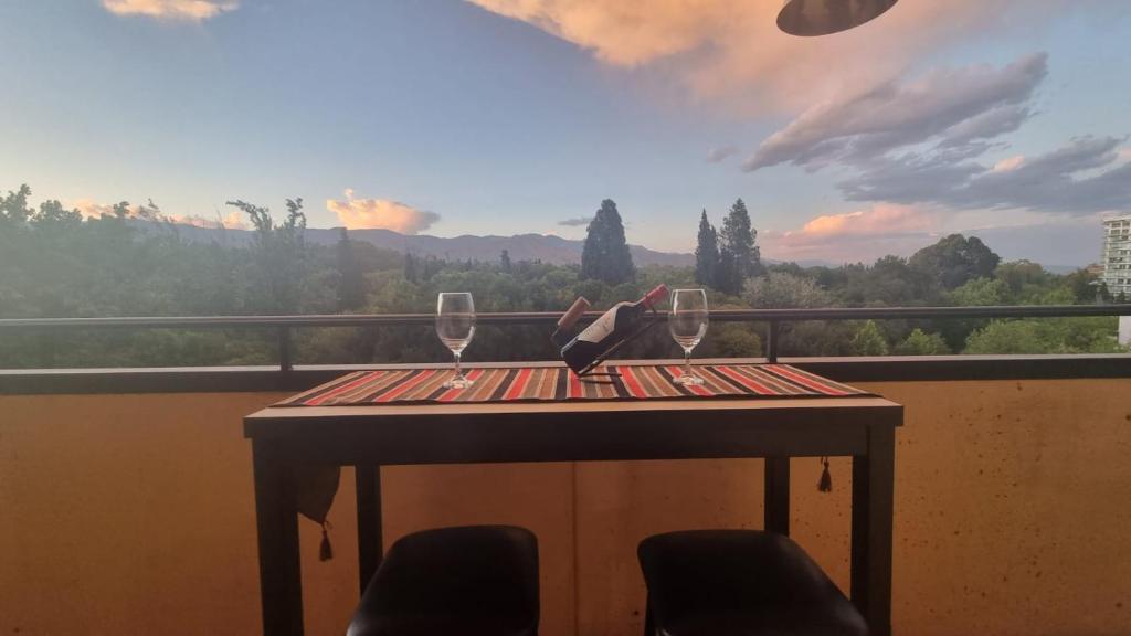 een tafel met twee wijnglazen op een balkon bij RECUERDAME in Mendoza