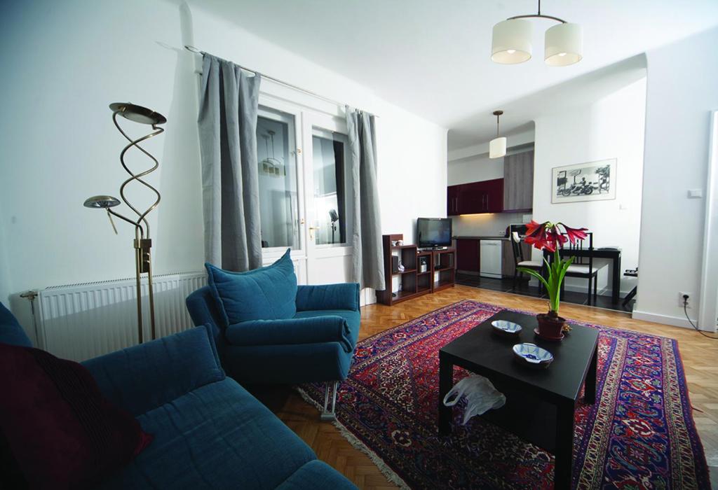 uma sala de estar com um sofá azul e uma mesa em Judy and Sandor Apartmen em Budapeste