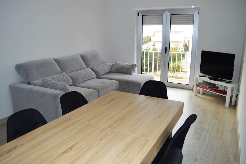 ein Wohnzimmer mit einem Sofa und einem Holztisch in der Unterkunft Market Apartment - VPA in Vila Praia de Âncora