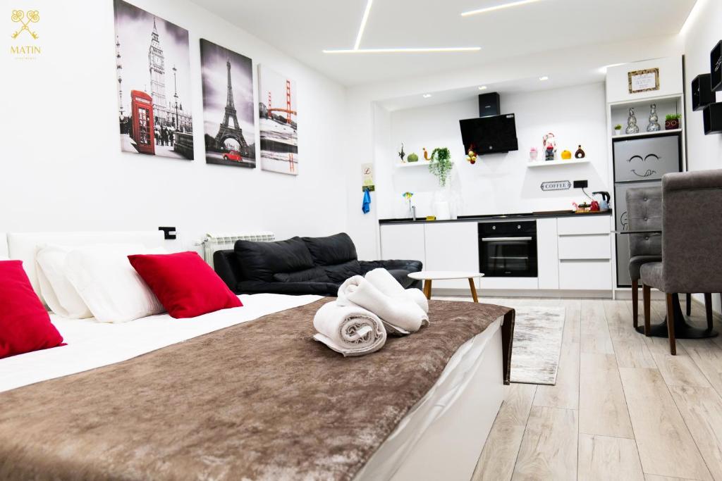 a bedroom with two beds and a living room at Matin Apartments in Pristina, Kosovo in Pristina