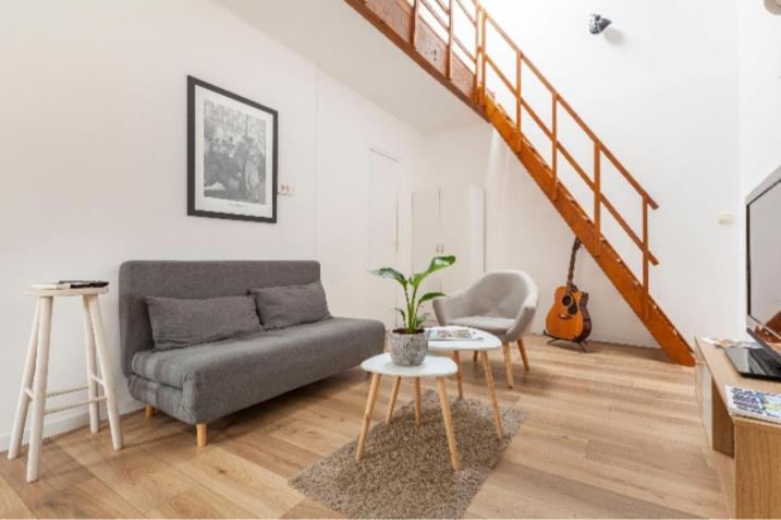 a living room with a couch and a stair case at Le 7 in Sète