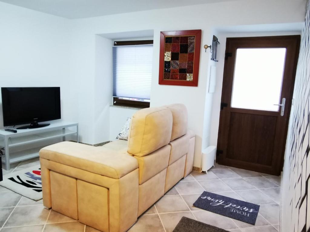 ein Wohnzimmer mit einem Stuhl und einem TV in der Unterkunft El Viaje a Elba Centro y Playa in Vilagarcia de Arousa