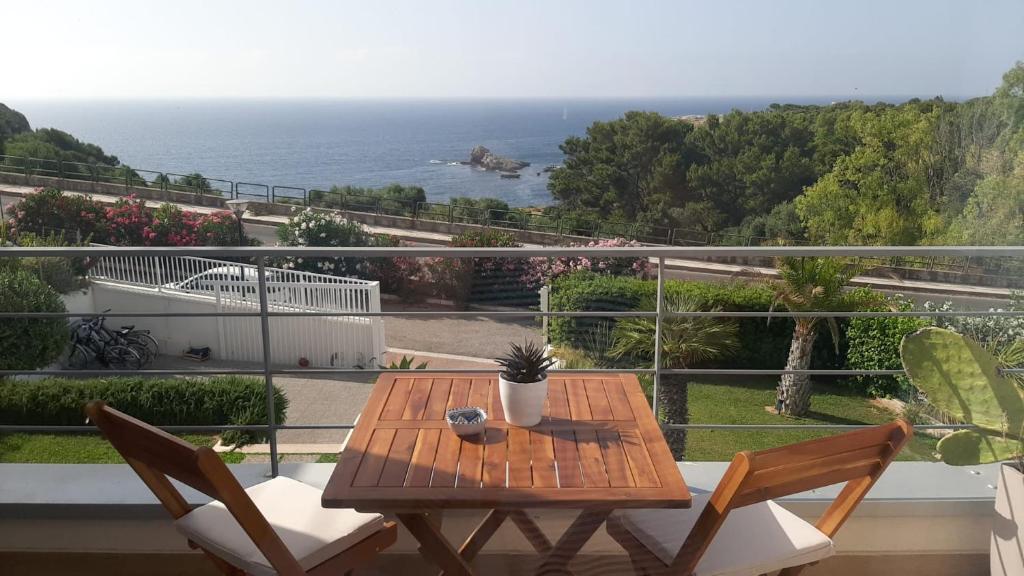 a wooden table and chairs on a balcony with the ocean at Zabbàra B&B in Terrasini