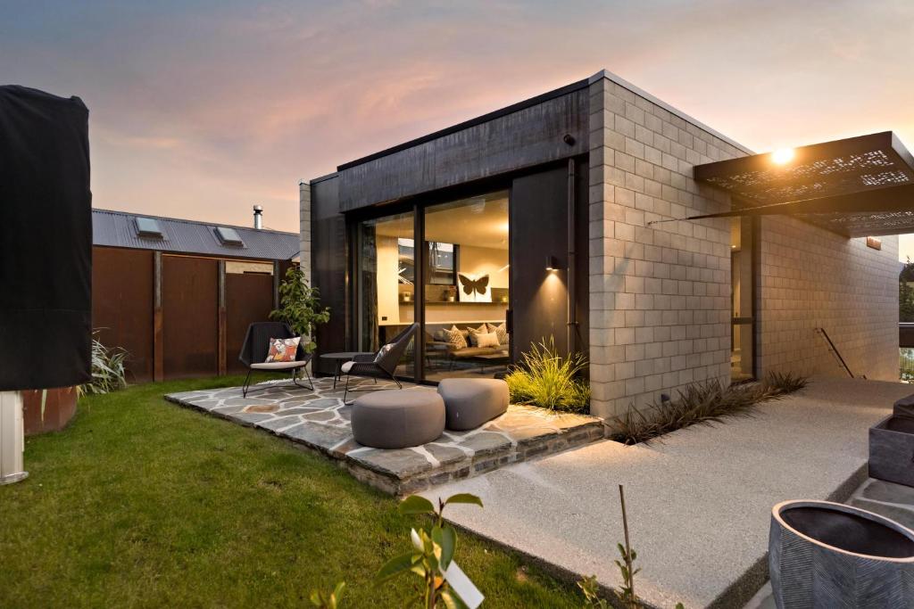 a modern house with a patio and a yard at The Ivy Box Apartment in Queenstown