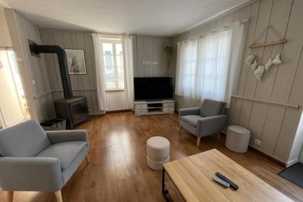 een woonkamer met een bank en een tv bij House in the center and near the beach in Rivedoux-Plage