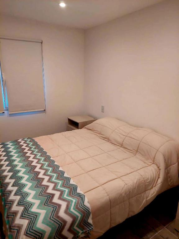 een slaapkamer met een bed in een kamer bij Departamento playa bonita Bariloche in Bariloche