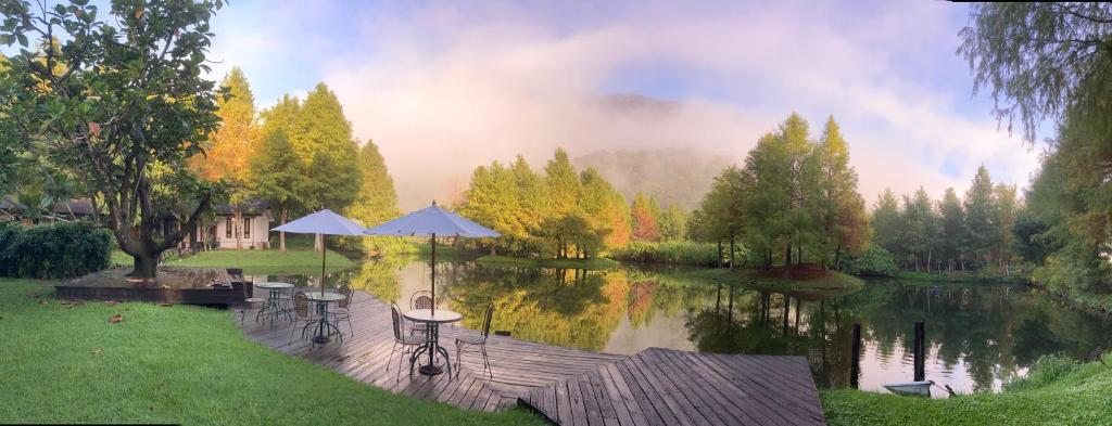 a view of a lake with tables and umbrellas at Grace Garden Villa in Fengshan