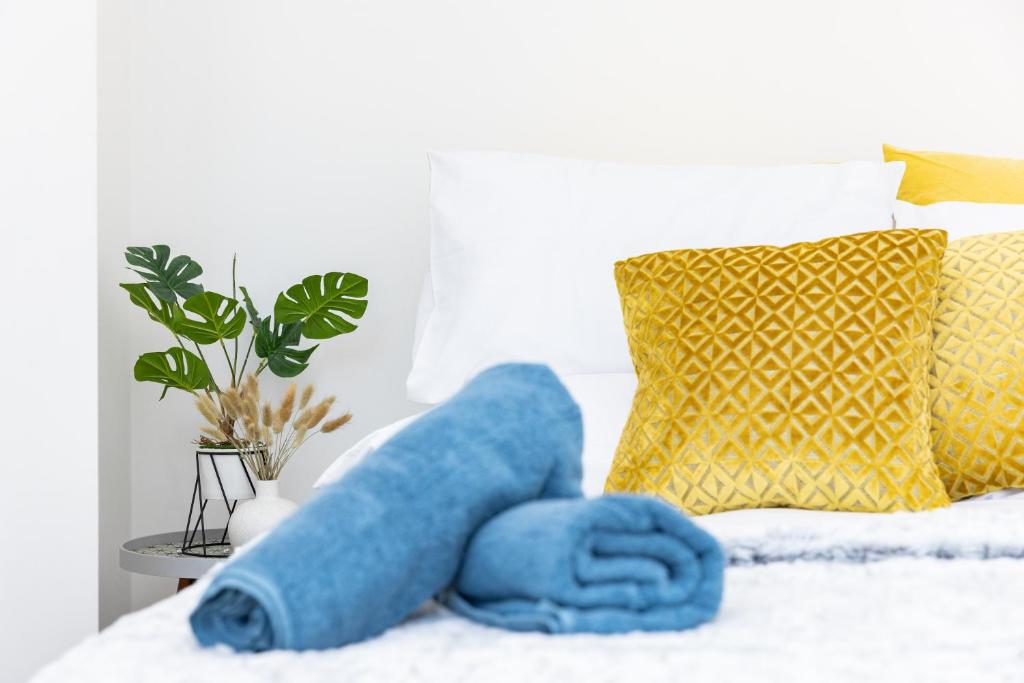 a blue towel on a bed with a yellow pillow at Warwick West in Barrow in Furness