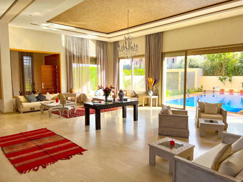 uma sala cheia de móveis e uma piscina em Riad villa saphir & SPA em Marraquexe