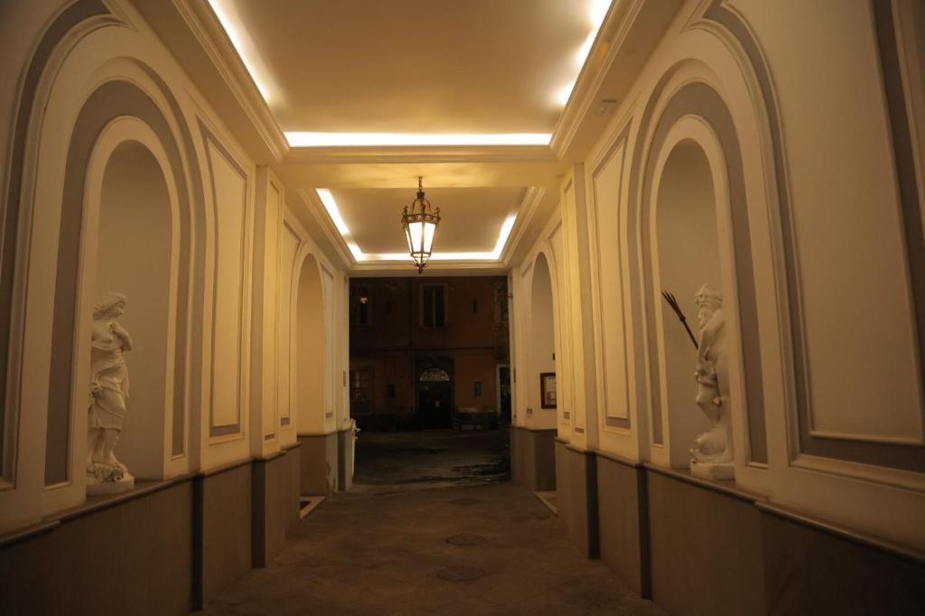 un pasillo vacío con una lámpara de araña en un edificio en B&B Scarlatti 60, en Nápoles