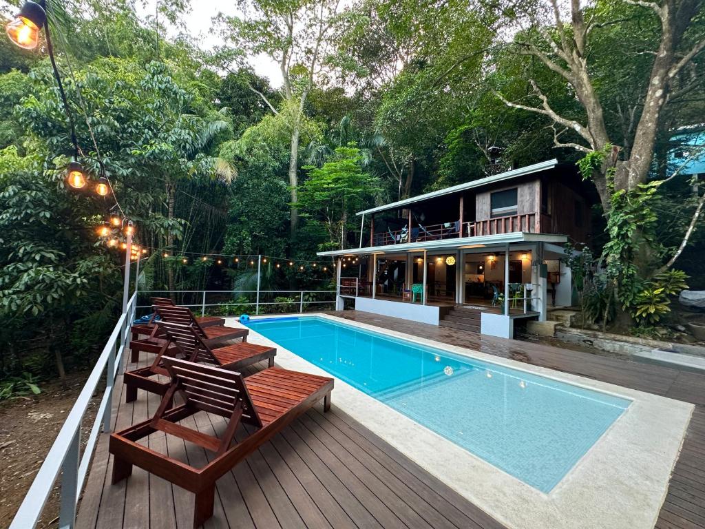 a house with a swimming pool and chairs on a deck at Luz En El Cielo Eco-B&B/Hostel in Montezuma