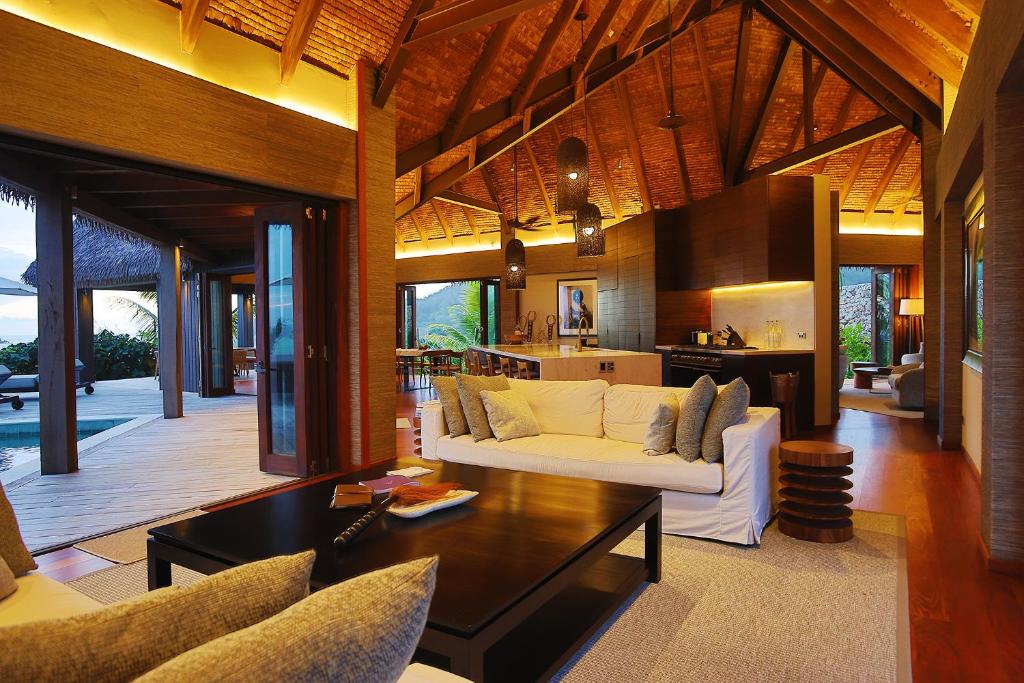 Villa Malolo Levu في مالولو: غرفة معيشة مع أريكة بيضاء ومطبخ