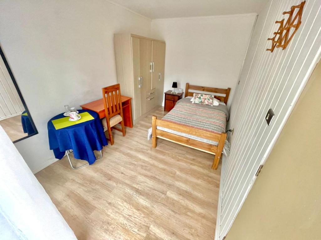 Cette petite chambre comprend un lit et une table. dans l'établissement Dulces Sueños, à Chillán
