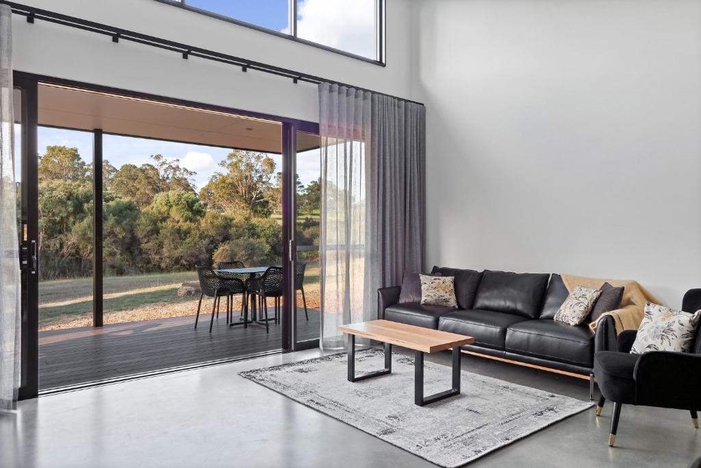 a living room with a couch and a table at Ruse Estate Retreat Margaret River in Rosa Glen