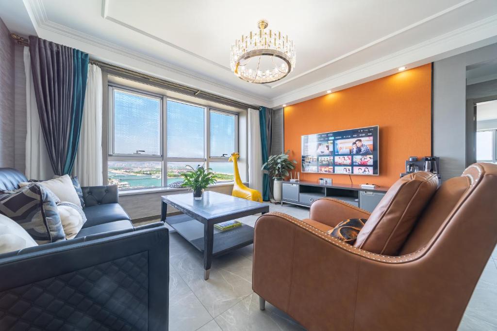 a living room with a couch and a tv at Cloud & Sea Boutique Apartment in Rizhao