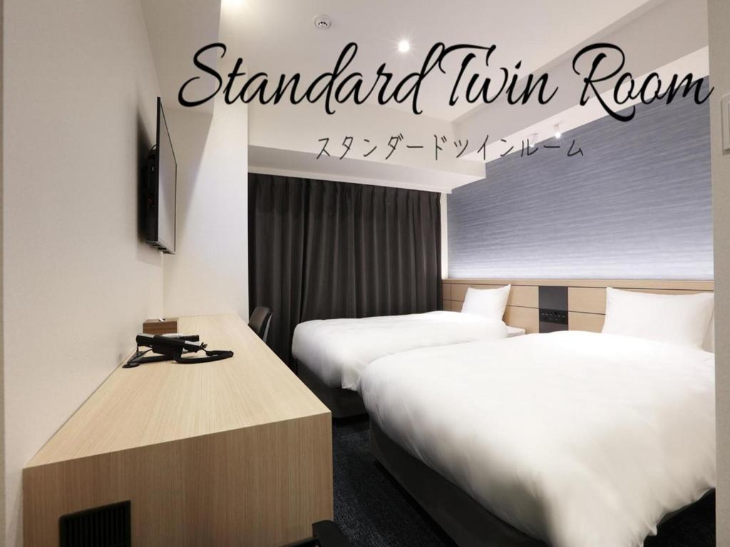 a hotel room with two beds and a sign that reads standard twin room at Henn na Hotel Premier Nagoya Fushimiekimae in Nagoya