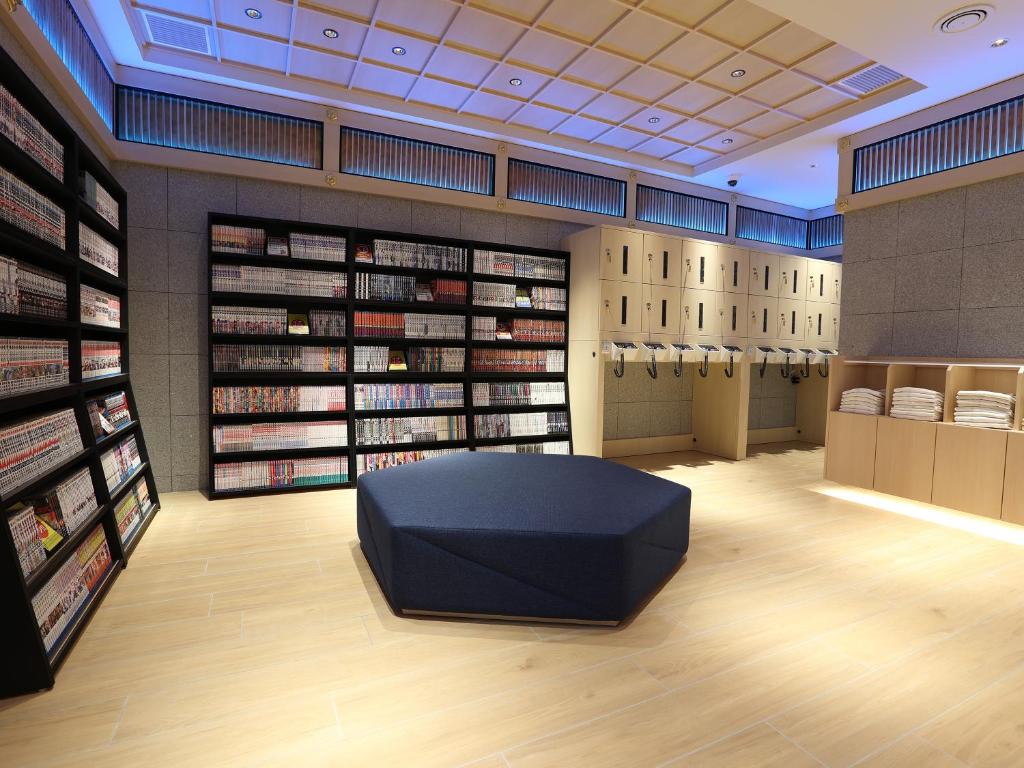eine Bibliothek mit einer schwarzen Ottomane in der Mitte in der Unterkunft Henn na Hotel Express Nagoya Fushimi Ekimae in Nagoya