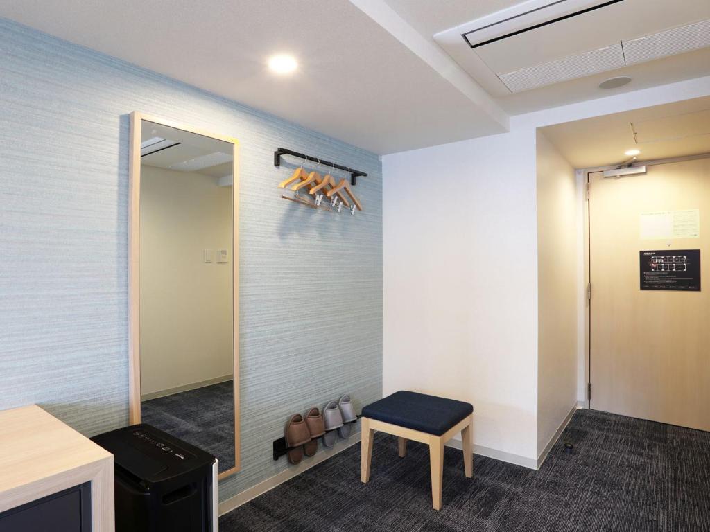 a waiting room with a chair and a mirror at Henn na Hotel Premier Nagoya Fushimiekimae in Nagoya