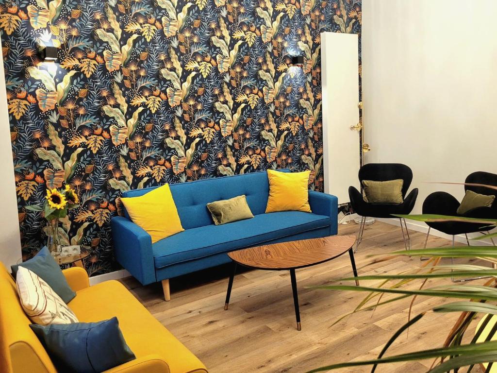 ein Wohnzimmer mit einem blauen Sofa und einer Blumentapete in der Unterkunft Brand new CAMELIA ROOM with private bathroom in Brüssel