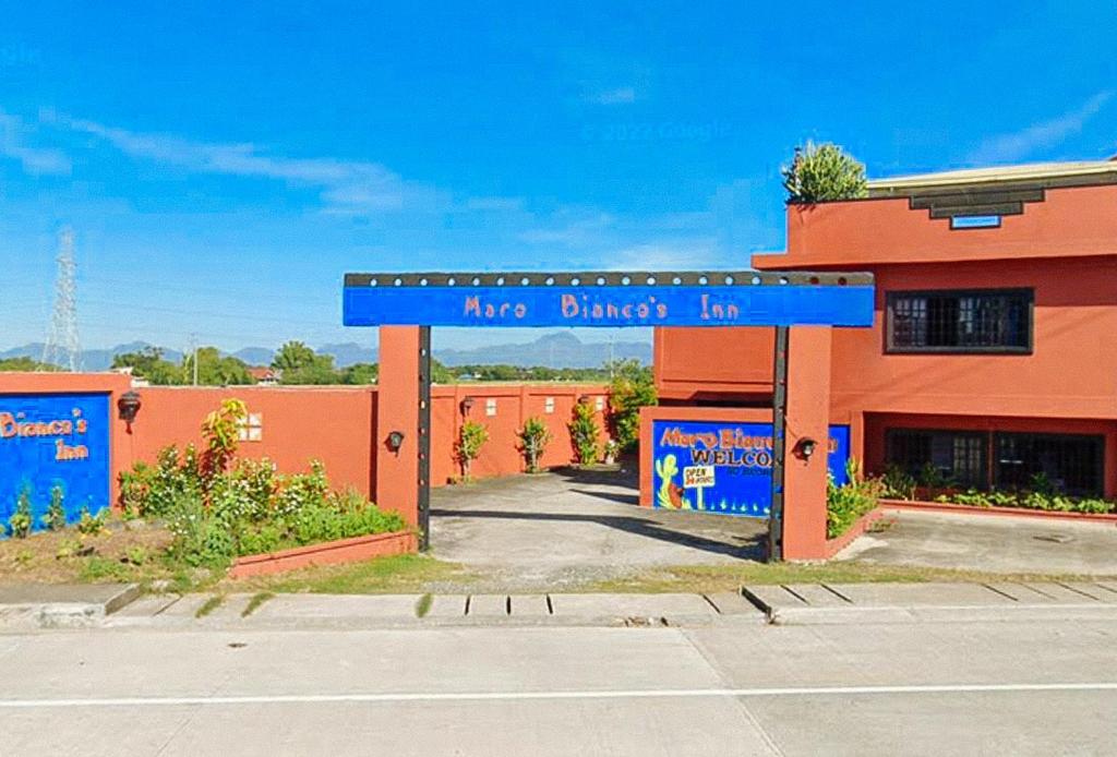 un edificio con un cartello blu che dice "May Dinner Inn" di Maro Bianco's Inn Lubao Pampanga by RedDoorz a Lubao