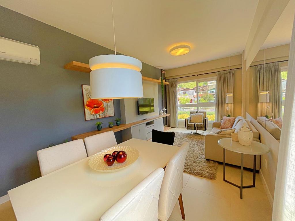sala de estar con mesa blanca y sala de estar con sofá en Apartamento ha 3 minutos da Rua Coberta - Gramado, en Gramado