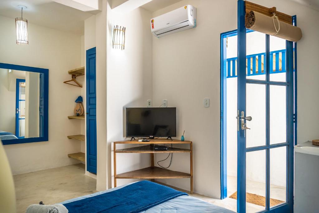 a room with a bed and a tv and a window at Villa Hortencia Trancoso in Trancoso