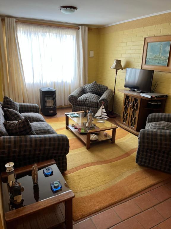 Sala de estar con 2 sofás y mesa de centro en Cabaña Algarrobo, en Algarrobo