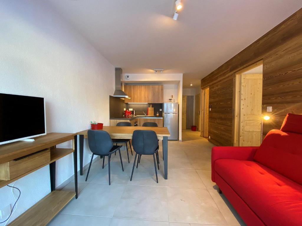 - un salon et une cuisine avec un canapé rouge et une table dans l'établissement Appartement Châtel, 3 pièces, 6 personnes - FR-1-693-48, à Châtel